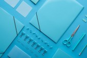 flat lay of paper binders and various arranged stationery isolated on blue 