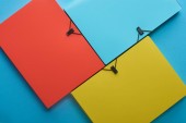 top view of arranged colorful paper folders on blue