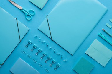 kağıt bağlayıcılar ve organize kırtasiye düz yatıyordu mavi izole 