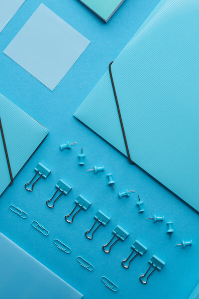 top view of paper folders and various stationery isolated on blue 