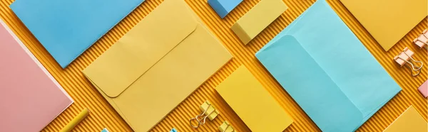 panoramic shot of colorful organized office stationery supplies on yellow