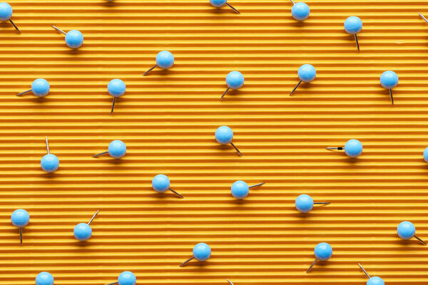 верхний вид штифтов на текстурной желтой бумаге
