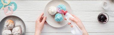 beyaz masa üzerinde buzlanma çantası ile kadın dekorasyon cupcakes panoramik çekim