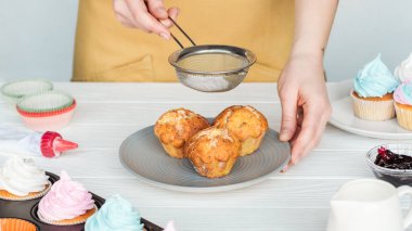 gri izole pudra şekeri ile kadın dekorasyon cupcakes kısmi görünümü