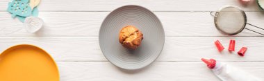 panoramic shot of delicious muffin and baking tools on wooden table clipart