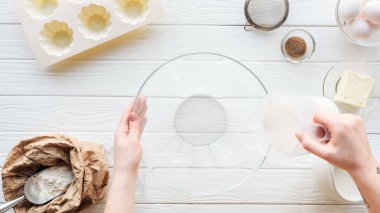 masada yemek yaparken kaseye şeker döken kadının kırpılmış görünümü