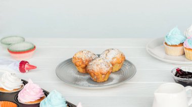 gri izole beyaz ahşap masada lezzetli cupcakes ve kekler