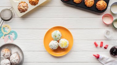 beyaz ahşap masa üzerinde lezzetli cupcakes ve pişirme araçları üst görünümü
