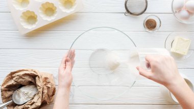 masada yemek yaparken kaseye şeker döken kadının kırpılmış görünümü