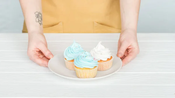 Bijgesneden Beeld Van Vrouw Holding Plaat Met Heerlijke Cupcakes Grijs — Stockfoto