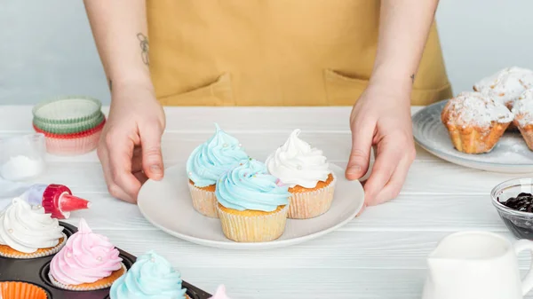 Abgeschnittene Ansicht Einer Frau Mit Teller Mit Cupcakes Auf Tisch — Stockfoto