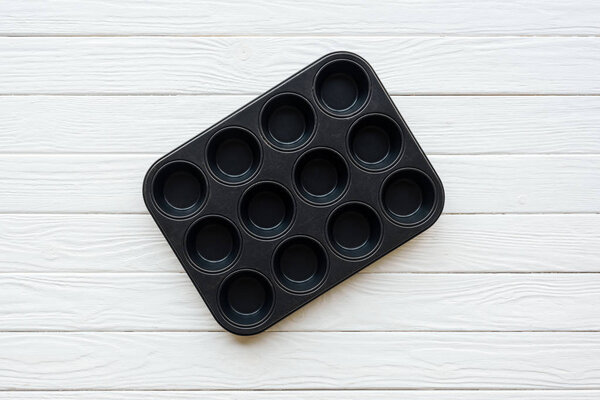 top view of metal muffin tray on white wooden table