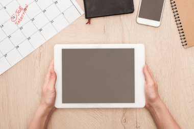 partial view of recruiter holding digital tablet with blank screen at workplace