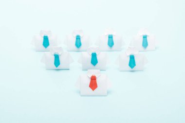 mavi arka plan, liderlik kavramı bir kırmızı ile mavi kravatlı origami beyaz gömlek