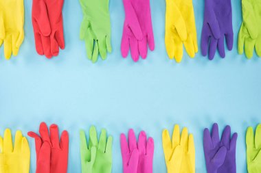 top view of multicolored bright rubber gloves on blue background with copy space clipart