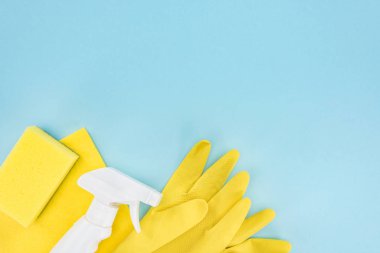 kopya alanı ile mavi arka plan üzerinde sarı lastik eldiven, sünger, bez ve sprey üst görünümü