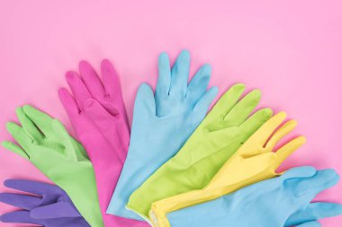 pembe arka plan üzerinde çok renkli kauçuk eldiven üst görünümü