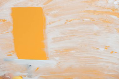 squeegee near glass covered with white foam on orange background clipart