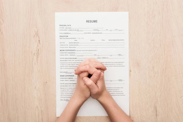 Partial View Recruiter Holding Clenched Hands Resume Template Wooden Table — Stock Photo, Image