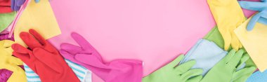 panoramic shot of multicolored rags and rubber gloves on pink background with copy space clipart