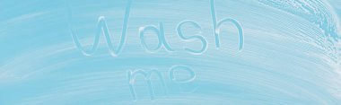 panoramic shot of glass covered with white foam on blue background with wash me lettering clipart
