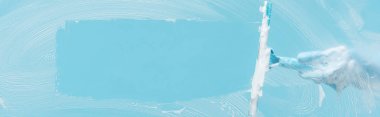 panoramic shot of woman in rubber glove cleaning glass with squeegee on blue background clipart