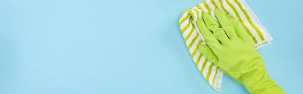 Панорамный Снимок Очистителя Зеленой Резиновой Перчатке Полосатой Тряпкой Синем Фоне — стоковое фото