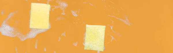 Plano Panorámico Esponjas Amarillas Con Espuma Sobre Fondo Naranja — Foto de Stock