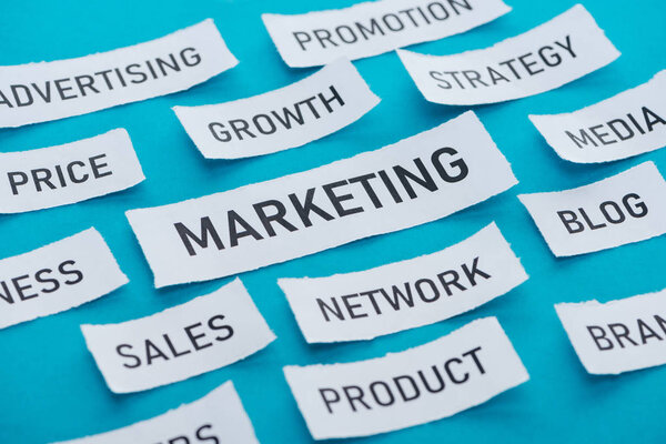 marketing components on pieces of paper on blue 