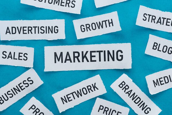 top view of components of marketing on pieces of paper on blue 