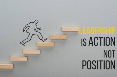 top view of drawn man running on wooden blocks symbolizing career ladder near leadership is action not position inscription on grey background, business concept clipart