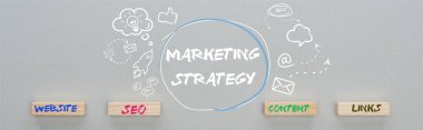 panoramic shot of marketing strategy inscription near multimedia icons illustration and wooden blocks with website, seo, content, links words on grey background,  business concept clipart