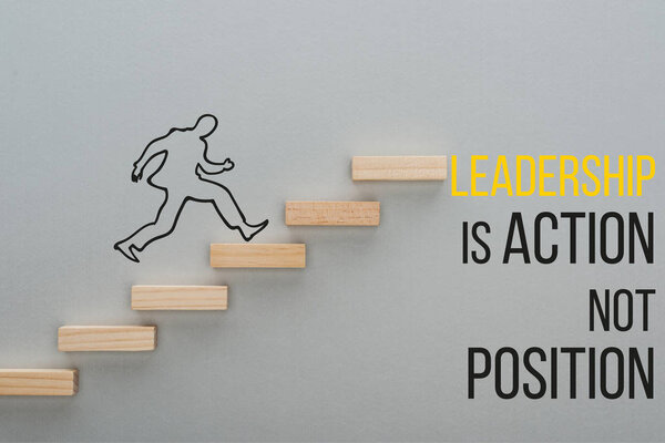 top view of drawn man running on wooden blocks symbolizing career ladder near leadership is action not position inscription on grey background, business concept