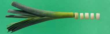 Panoramic shot of chopped green nutritious leek isolated on green clipart