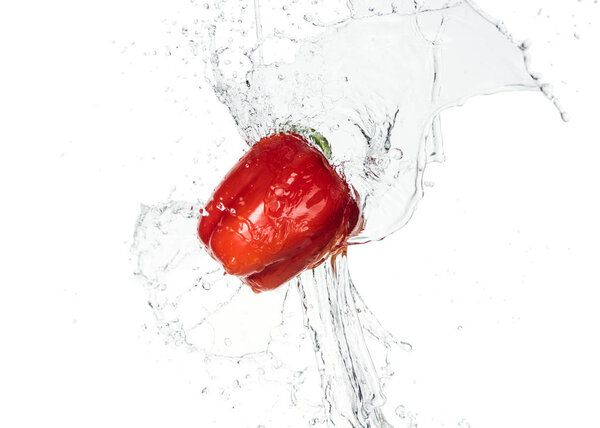 whole tasty fresh red bell pepper with clear water splash isolated on white