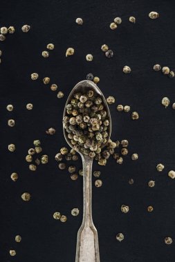 siyah arka plan üzerinde gümüş kaşık baharat üst görünümü