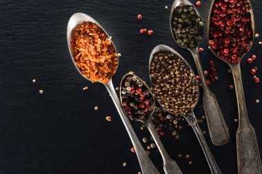 siyah dokulu arka plan üzerinde gümüş kaşık biber, şekerlenmiş meyve ve hardal üst görünümü