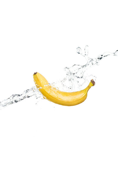 whole ripe yellow banana and water splash isolated on white