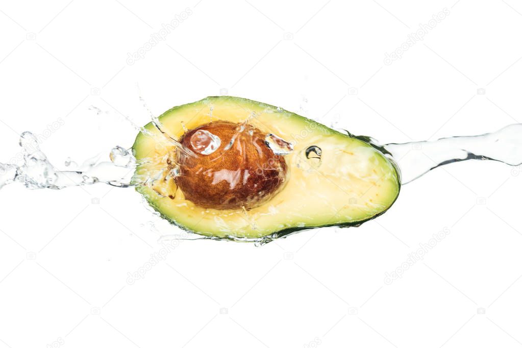 ripe nutritious avocado with seed and transparent water stream isolated on white 