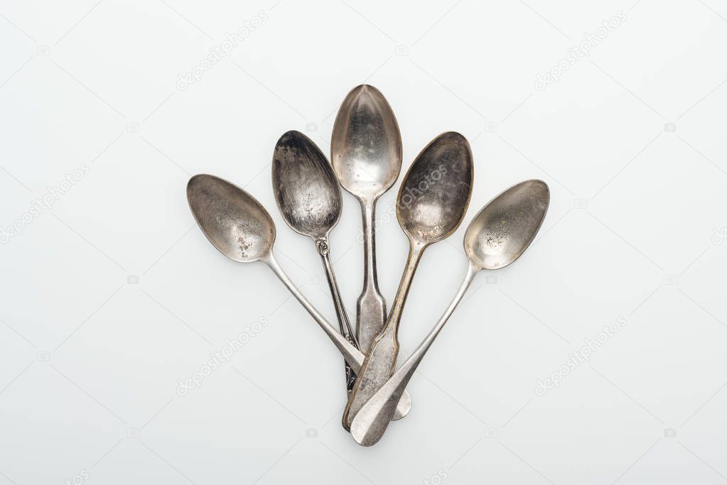 top view of shiny aged silver empty spoons on white background
