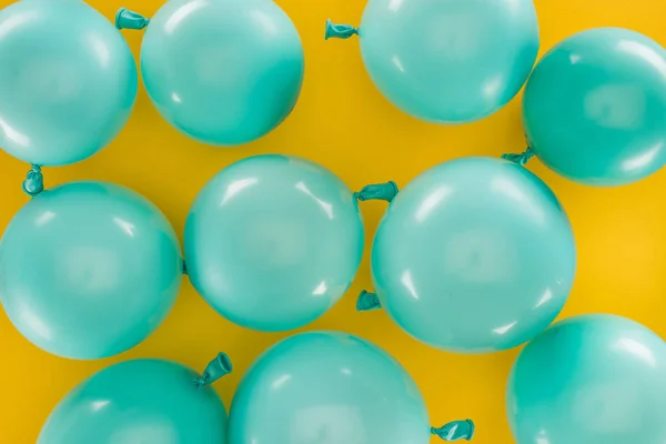 黄色のお祝いの背景に青い風船のトップビュー — ストック写真