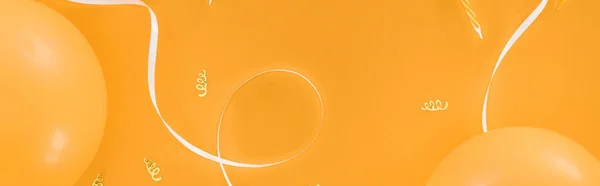 オレンジ色の背景に黄色の風船とパーティーの装飾のパノラマショット — ストック写真