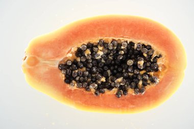 beyaz izole siyah tohumları ile olgun egzotik papaya yarısı yakından görünümü