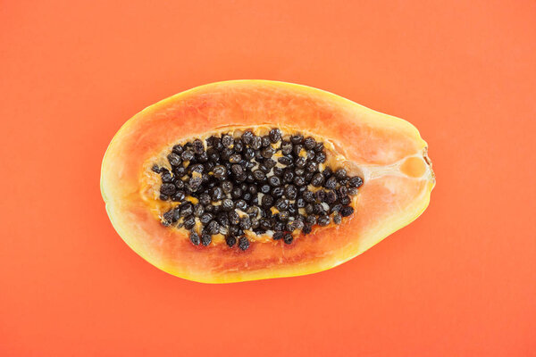 top view of ripe exotic papaya half isolated on orange