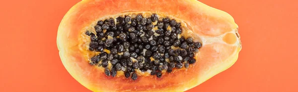 オレンジ色に隔離された黒い種子を持つ熟したパパイヤ半分のパノラマショット — ストック写真
