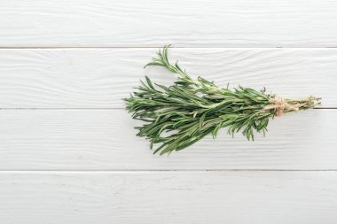 top view of fresh green rosemary on white wooden table clipart