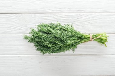 top view of fresh green dill on white wooden table clipart