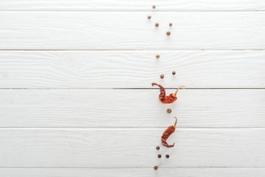 beyaz ahşap masa üzerinde dağınık karabiber ve kurutulmuş biber üst görünümü