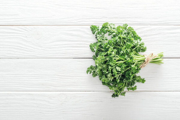 top view of green parsley on white wooden table