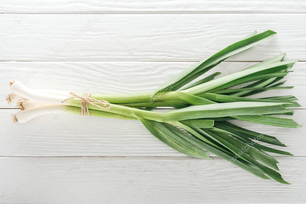 top view of fresh green leek on white wooden table